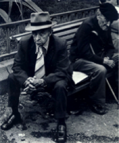 Black and white photo of 2 older Spanish men on a bench