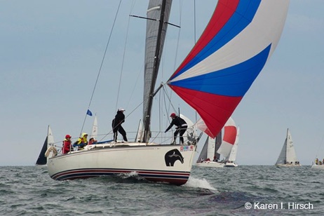 Racing sailboat with red, white and blue spinnaker