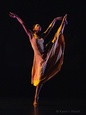 Woman African-American dancer in dress with leg lifted and toe pointed