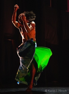 Male African-American dancer in motion,  bare chested with green toga like skirt