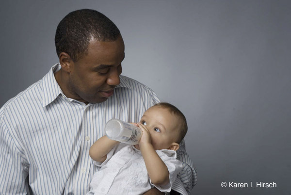 Black man and baby drinking from bottle