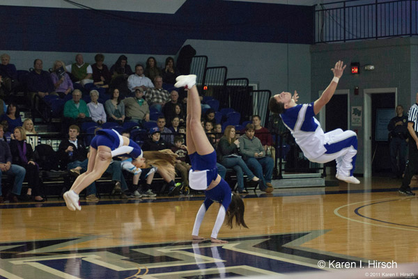 Cheerleaders flipping on basketball court - High Point University